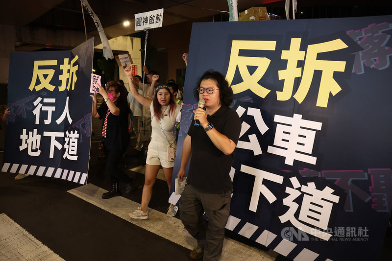 參與者帶著大型看板表達訴求,沿行穿線繞行圓環。中央社記者王騰毅攝 114年9月12日