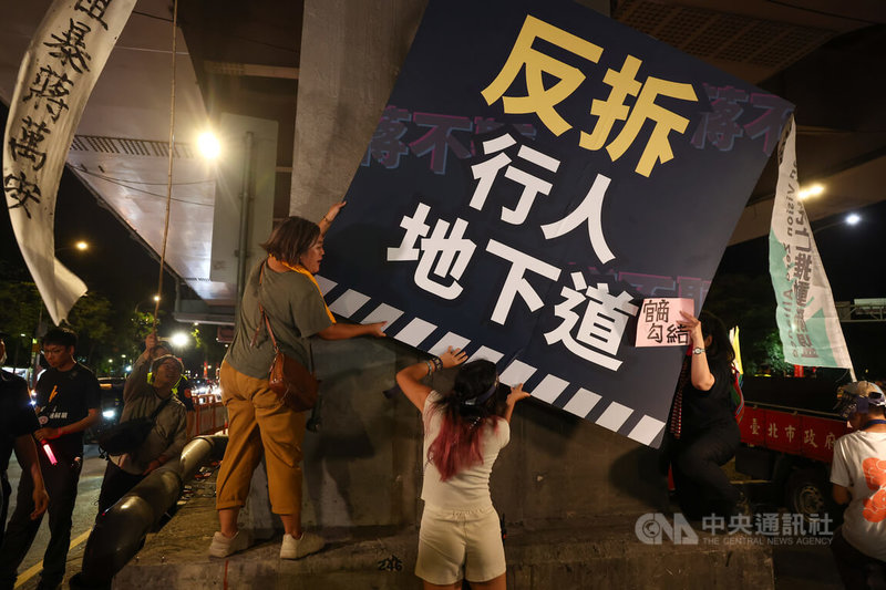 參與者在梁柱處掛上看板傳達抗議立場。中央社記者王騰毅攝 114年9月12日