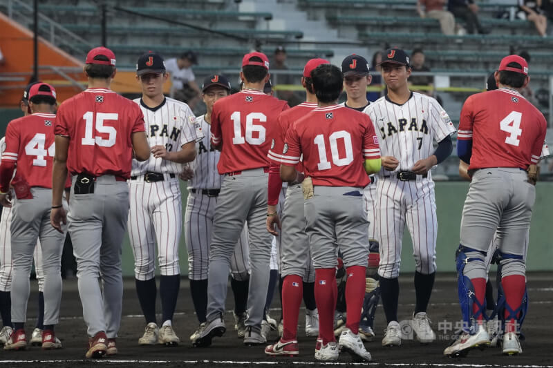U18世界盃棒球賽晉級關係確定，日本隊（白衣）與巴拿馬隊（紅衣）12日複賽交手鏖戰至延長賽9局，終場由日本以6比5險勝，將與美國爭冠，同時也確定季軍戰組合為台灣對韓國。圖為日本與巴拿馬球員晚間賽前先禮後兵。中央社記者徐肇昌沖繩攝  114年9月12日