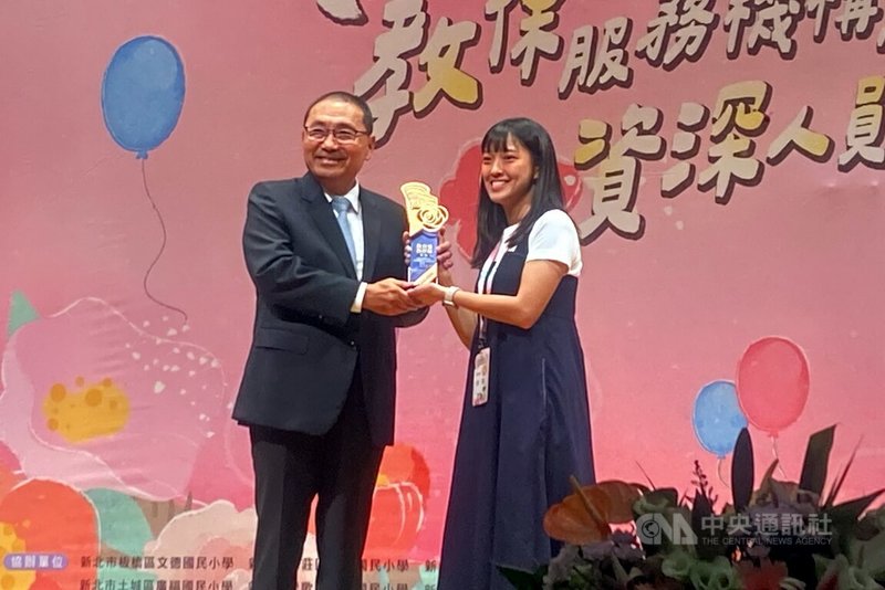 新北市府教育局13日表揚教保服務機構與人員，向493名獲獎者致敬，市長侯友宜（左）頒發獎座給中和幼兒園教師林昀（右）。她曾協助緊急安置幼兒，透過耐心陪伴，幫助孩子走出創傷。中央社記者黃旭昇新北攝　114年9月13日