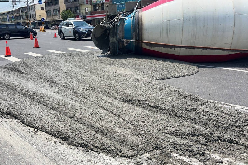 一輛預拌混凝土車14日在台南市官田區擦撞路口處行人庇護島，子車翻覆橫倒車道，混凝土污染路面。（讀者提供）中央社記者楊思瑞台南傳真  114年9月14日