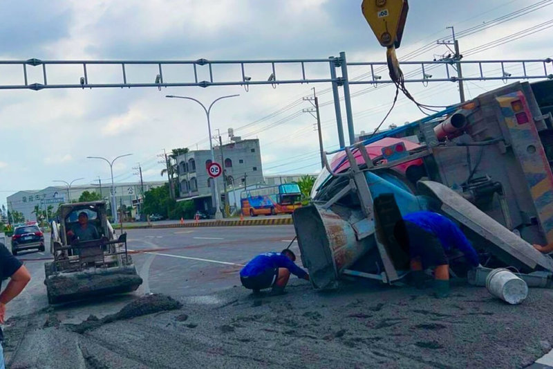 鄭姓男子14日駕駛預拌混凝土車,由台南市官田區南廍里南318線欲左轉台1線北上時,於路口擦撞行人庇護島,造成子車翻車橫倒車道,警方聯繫拖吊車及工務單位協助清理排除事故現場。(讀者提供)中央社記者楊思瑞台南傳真 114年9月14日