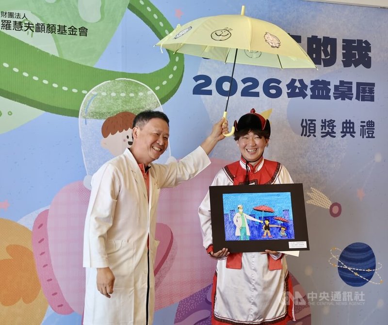 羅慧夫顱顏基金會「未來的我」2026公益桌曆頒獎典禮暨開賣記者會，14日在台北孫運璿科技人文紀念館B1多功能講堂舉行，海外得獎人來自蒙古的15歲男孩塔米爾•布彥（TAMIR BUYAN）身穿傳統蒙古服飾出席領獎，左為長庚醫院顱顏中心醫師羅綸洲。中央社記者王飛華攝　114年9月14日