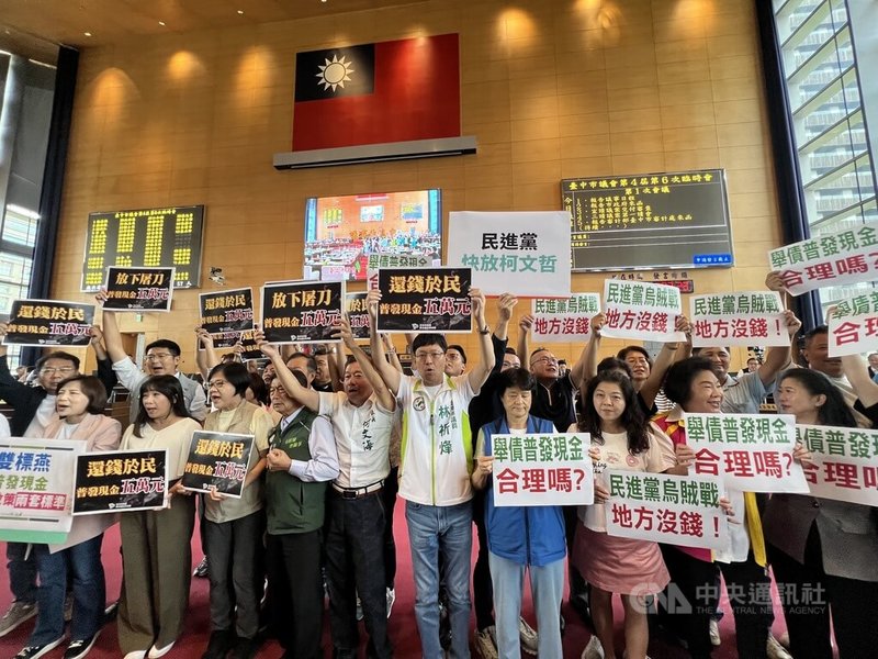 台中市議會臨時會15日開議,民主進步黨團會中高舉海報要求台中市政府普發現金新台幣5萬元,而中國國民黨團也舉牌要求民進黨不要打烏賊戰。中央社記者郝雪卿攝 114年9月15日