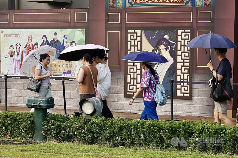 中央氣象署15日下午更新高溫資訊,各地天氣高溫炎熱,高雄市為黃色燈號,注意攝氏36度以上高溫。圖為高雄駁二藝術特區周邊民眾撐傘遮陽。中央社記者董俊志攝 114年9月15日
