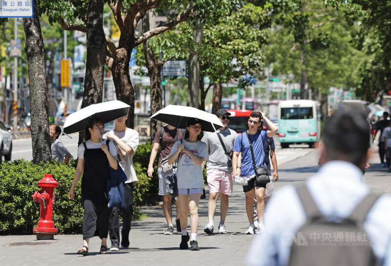 圖為台北市大安區上午天氣晴朗炎熱,路上行人撐傘遮蔭。(中央社檔案照片)