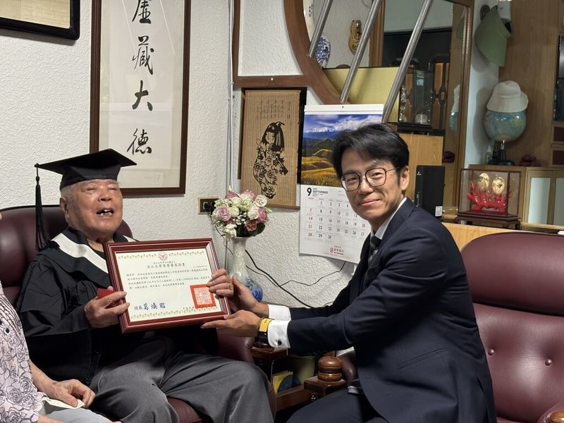白色恐怖受難者趙清淵（左）16日接受淡江大學學生事務處生活輔導組組長虢恕仁（右）頒贈榮譽畢業證書，並獲贈1套文學院學士袍，完成專屬於他的畢業典禮。（人權館提供）中央社記者王寶兒傳真　114年9月16日