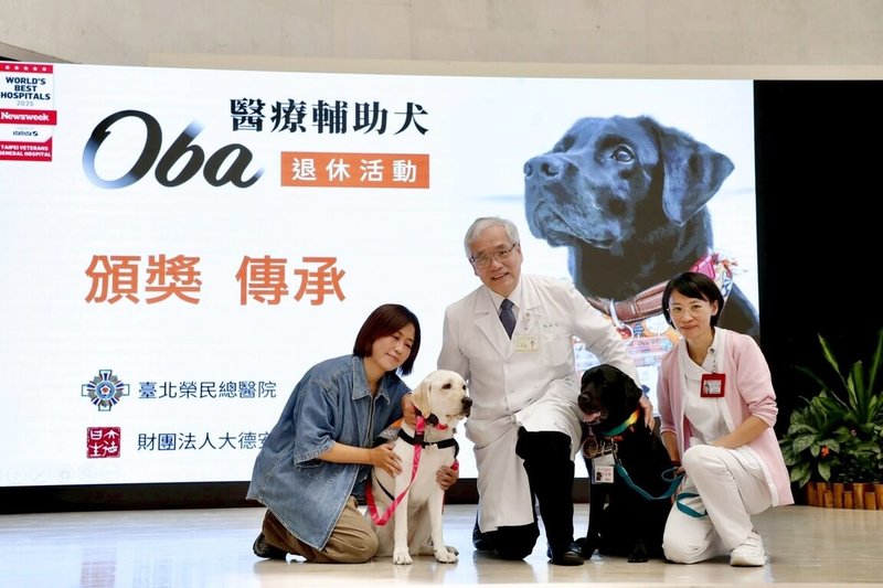 全台首隻駐點醫院的輔助治療犬「歐巴」（黑犬）16日在北榮院長陳威明（中）見證下正式退休，牠的工作將由3歲「學妹」歐佳（白犬）接手。（北榮提供）中央社記者曾以寧傳真　114年9月16日