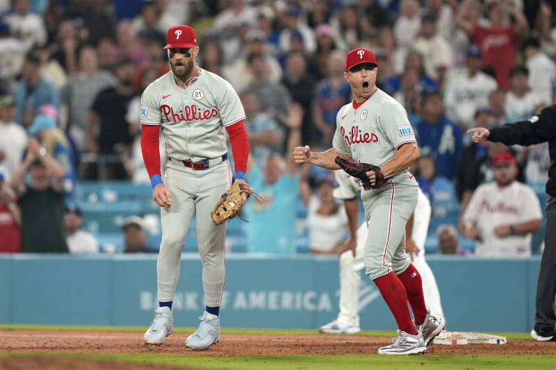 MLB費城人球星哈波（左）和羅伯森（右）15日在場中慶祝勝利。（美聯社）