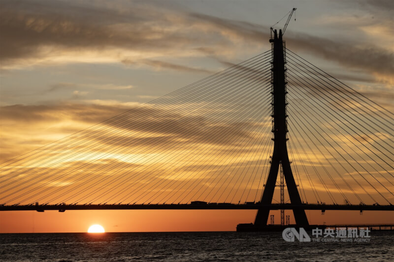 圖為從淡水老街遠眺施工中的淡江大橋與夕陽。中央社記者趙世勳攝 114年9月16日