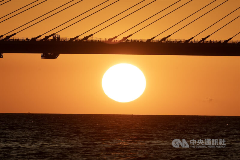 世界最長跨距的單塔不對稱斜張橋「淡江大橋」最後一個節塊16日到位，預計民國115年5月完工通車，連結新北市淡水、八里兩地，橋梁之美並融入淡江夕照。圖為傍晚時分，夕陽緩緩西沉，逐漸低於淡江大橋、朝海平線落下。中央社記者趙世勳攝　114年9月16日