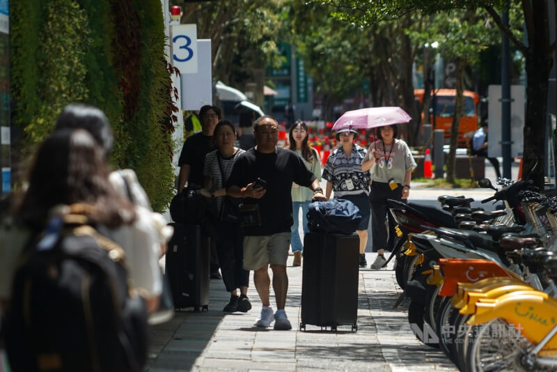 圖為民眾下午在台北市信義區外出，走在陰影下遮陽。（中央社檔案照片）