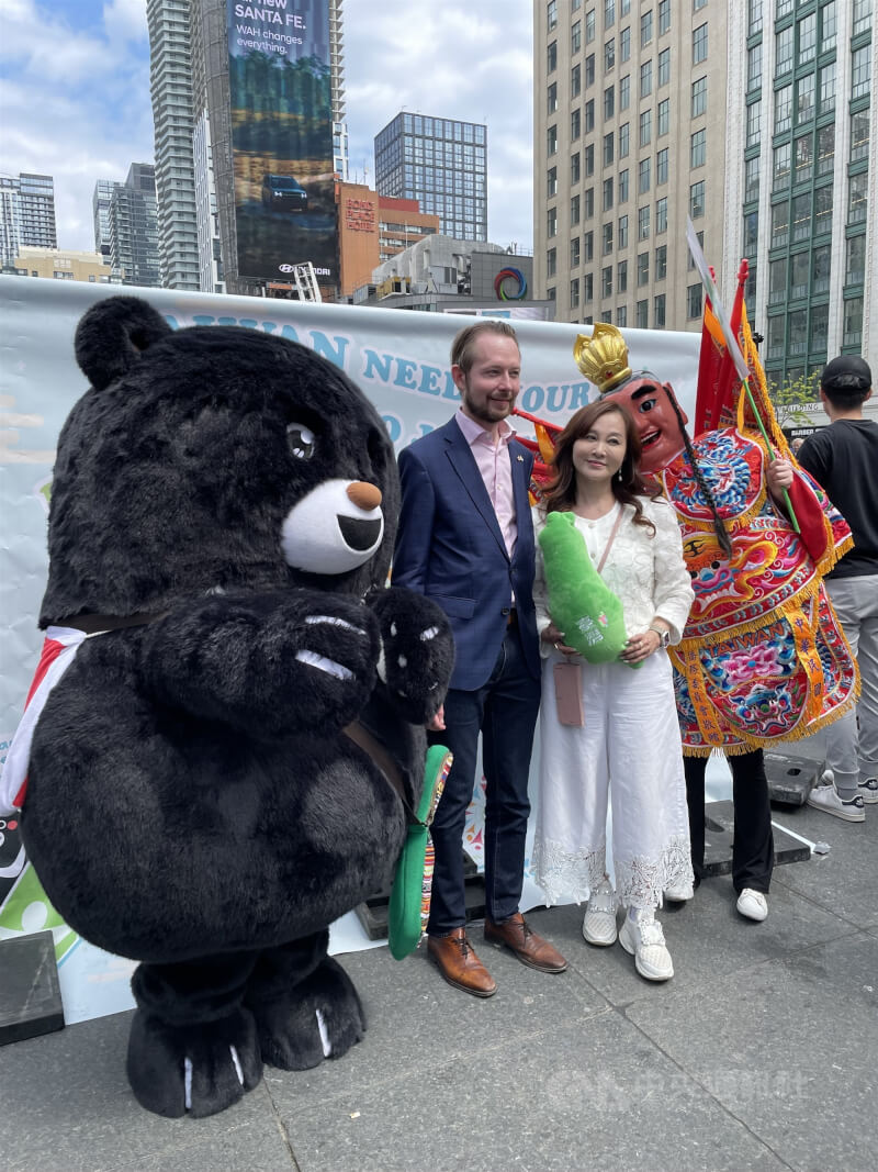 圖為加拿大保守黨聯邦眾議員古柏（左）2024年5月在多倫多僑界支持台灣參與WHA的活動現場，與多倫多僑務委員林美玲（右）、吉祥物「三太子」及「台灣黑熊」合影。（中央社檔案照片）
