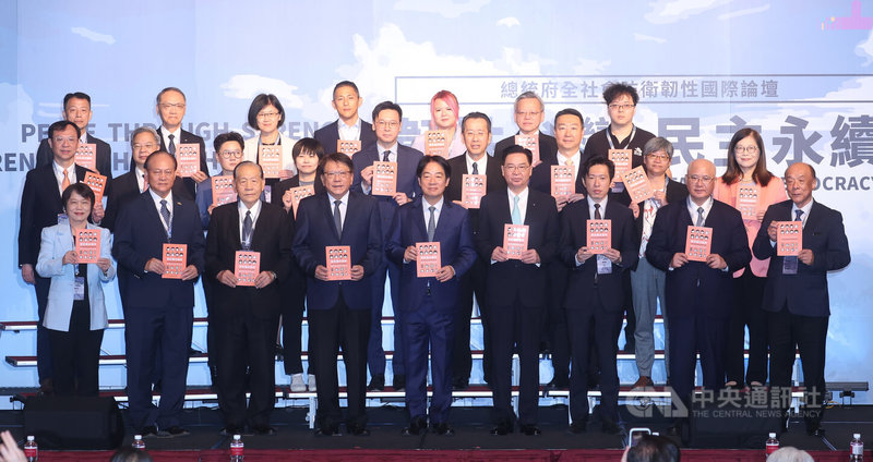 總統府全社會防衛韌性國際論壇20日在台北登場，總統賴清德（前中）、總統府秘書長潘孟安（前左4）、國安會秘書長吳釗燮（前右4）等人手拿新版全民國防手冊合影。中央社記者謝佳璋攝  114年9月20日