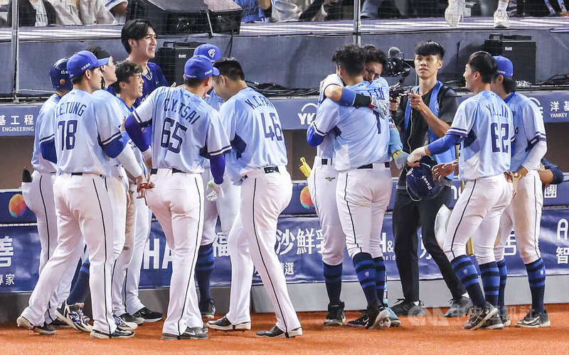 中華職棒富邦悍將陳真(右4背對者)21日在「悍將遊俠」林哲瑄(右5)生涯最終戰中,拿著林哲瑄的球棒轟出陽春砲,他在繞壘時就忍不住掉淚,回到休息室與林哲瑄擁抱時更是淚崩。中央社記者張新偉攝 114年9月21日