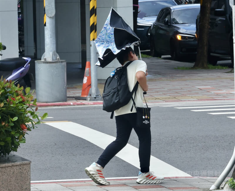 圖為台北街頭民眾雨傘被強風吹掀。(中央社檔案照片)