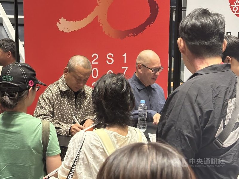 導演蔡明亮(右)與演員李康生(左)22日出席「不散」在釜山影展放映後,為現場觀眾簽名。中央社記者廖禹揚釜山攝 114年9月22日