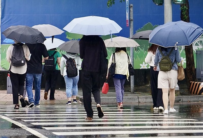 交通部中央氣象署表示，颱風樺加沙強度略減弱，23日上午8時30分已解除陸上颱風警報，圖為高雄市前金區持續出現雨勢，民眾撐傘過馬路。中央社記者董俊志攝 114年9月23日