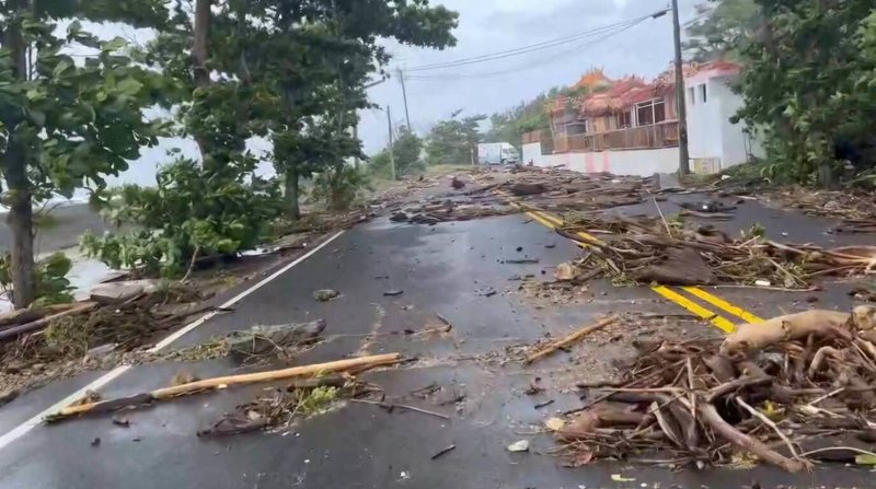 颱風樺加沙掃過，小琉球環島公路厚石群礁路段23日一早堆滿漂流木，有熱心居民拍下影片，提醒用路人避開此路段。（民眾提供）中央社記者黃郁菁傳真　114年9月23日