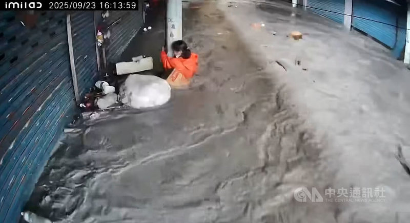 花蓮縣馬太鞍溪堰塞湖23日下午溢流，大水沖進光復鄉等區域，一名婦人在水流中抱著光復市場的柱子，女兒節錄監視器畫面在臉書社群求援引發關注，所幸晚間家屬表示，婦人已平安脫困。（翻攝臉書花蓮人）中央社記者張祈傳真  114年9月23日