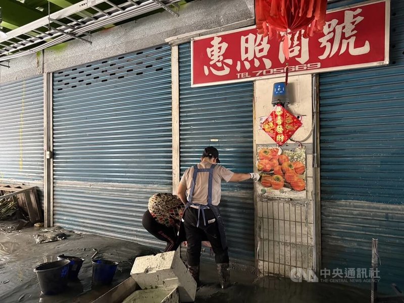 花蓮縣馬太鞍溪堰塞湖23日溢流,光復第一市場攤商24日陸續返回現場查看災損情形,一名攤商嘗試開門,但鑰匙孔已卡滿泥土,無法使用。中央社記者張祈攝 114年9月24日
