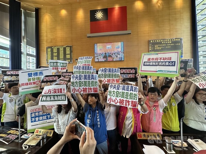台中市議會討論普發現金5萬，民進黨市議員要求還稅於民，國民黨市議員則認為普發現金是假議題，小心被詐騙。雙方各持看板，衝上官員席。中央社記者趙麗妍攝 114年9月24日