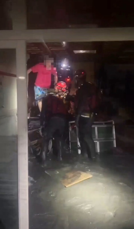 花蓮縣馬太鞍溪堰塞湖溢流釀災,屏東消防局馳援,進入滿是淤泥的房屋揹出受困民眾。(屏東消防局提供)中央社記者李卉婷傳真 114年9月24日