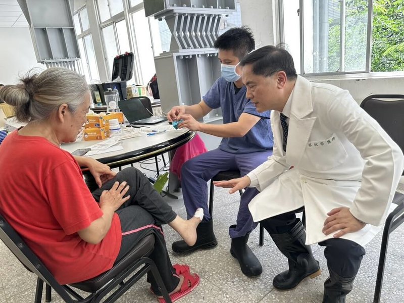 馬太鞍溪堰塞湖溢流,洪水越堤進入光復鄉造成嚴重傷亡。花蓮慈院醫療隊抵達光復糖廠醫療站,提供中西醫等專科醫護,花蓮慈院院長林欣榮(前右)25日為民眾治療腳部外傷傷口。(花蓮慈濟醫院提供)中央社記者洪學廣傳真 114年9月25日