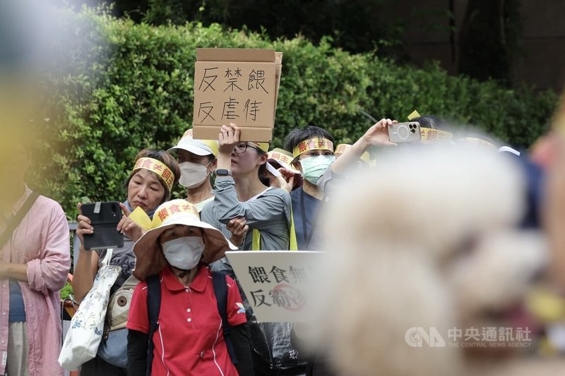 動保團體26日在農業部前集結舉辦「抗議政府餓死流浪貓狗」行動,有民眾拿著寫有「反禁餵、反虐待」標語表達訴求。中央社記者翁睿坤攝 114年9月26日