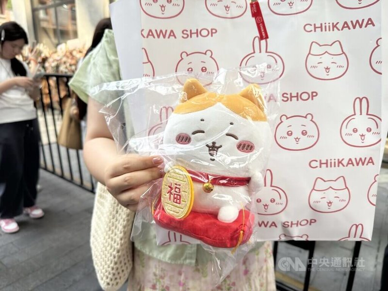 吉伊卡哇海外首間旗艦店27日上海開幕,販售限量款式「招財小八」,原價人民幣139元,現場黃牛加價400元販售。圖為民眾展示購買到的戰利品。中央社記者廖文綺上海攝 114年9月27日