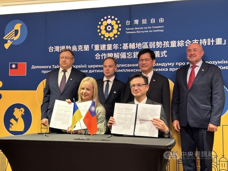 在外交部長林佳龍（後右2）及烏克蘭國會議員見證下，基輔市兒童與家庭福利局副局長巴迪列維奇（前左1）與波蘭台北代表處代表劉永健（前右1）簽署協助基輔地區弱勢孩童綜合支持計畫。中央社記者彭維楀華沙攝 114年9月29日