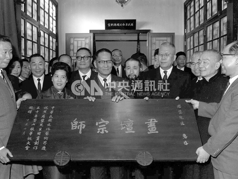在慶祝黃君璧國畫創作50年暨七秩華誕茶會上,黃君璧(中)接受各界贈送的「畫壇宗師」匾額。中央社記者馮國鏘攝 56年12月16日
