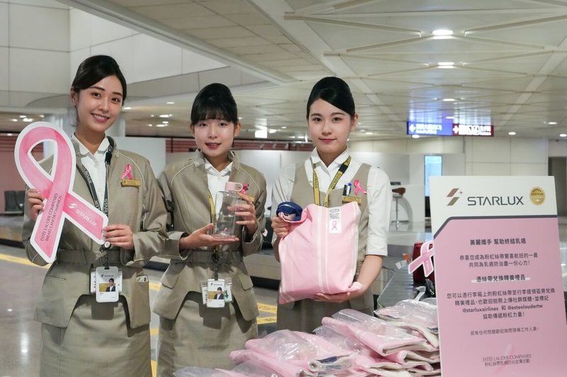 星宇航空2日攜手雅詩蘭黛集團與桃園國際機場公司，在桃園國際機場第二航廈入境行李提領區規劃快閃活動，由工作人員為抵台旅客行李繫上巨大紙製粉紅絲帶，除可兌換專屬托特包及水壺，也鼓勵旅客拍照分享至社群平台，傳遞粉紅驚喜正能量。（星宇航空公司提供）中央社記者吳睿騏桃園機場傳真　114年10月2日
