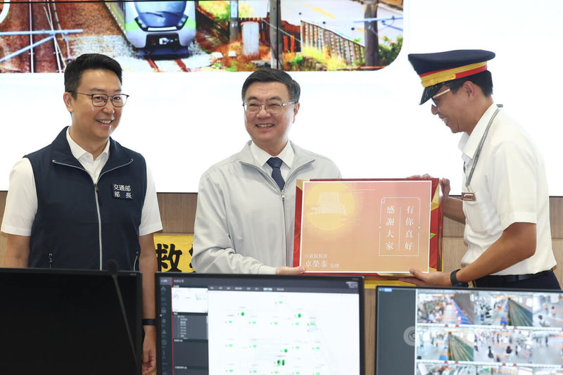 中秋連假前夕,行政院長卓榮泰(中)3日到台北車站聯合防災中心視察鐵公路疏運情形,並致贈禮盒給疏運相關工作人員。左為交通部長陳世凱。中央社記者王騰毅攝 114年10月3日