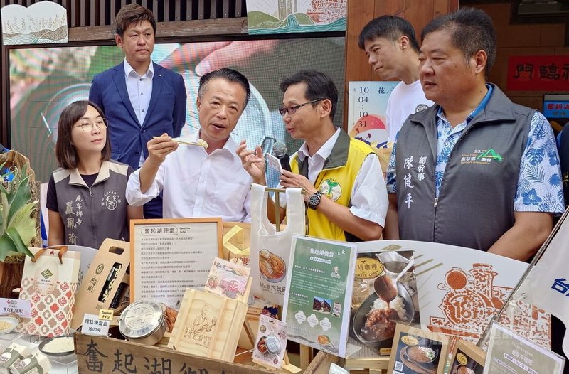 嘉義奮起湖大飯店新款鐵路便當使用鹿草牛奶香米(台南20號),此米研發者、台南農改場鹿草分場長陳榮坤(前右2)3日表示,牛奶香米有著牛奶色澤、香米的特質,口感Q彈好吃。前右3為嘉義縣長翁章梁。中央社記者蔡智明攝 114年10月3日