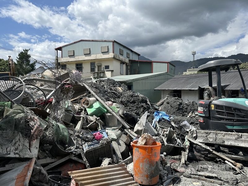 花蓮縣光復鄉邱姓婦人因馬太鞍溪堰塞湖溢流讓她的生財器具全被沖走，曾在0403地震中成為天王星大樓災民的她，如今又成洪災災民，住家後面還堆滿了土石廢棄物等待清理。中央社記者李先鳳攝　114年10月6日