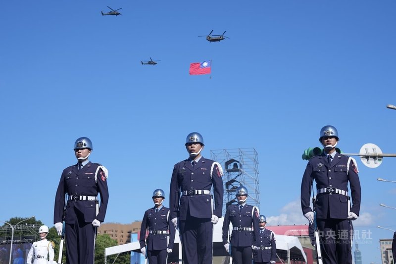 114年國慶大會預演6日在總統府前登場,進行至國歌領唱儀式時,空中2架UH-60M黑鷹直升機伴飛1架吊掛巨幅國旗的CH-47SD契努克運輸直升機,共同飛越凱達格蘭大道上空。中央社記者徐肇昌攝 114年10月6日