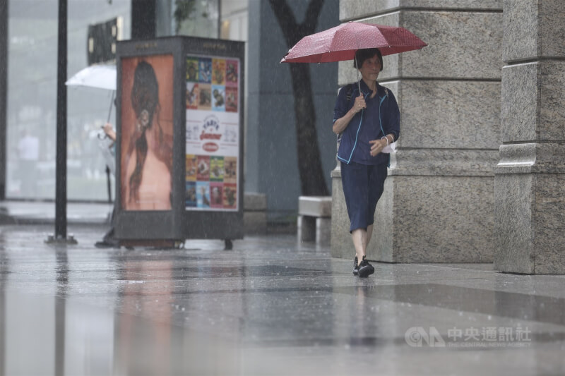 圖為台北市信義區民眾外出撐傘擋雨。（中央社檔案照片）