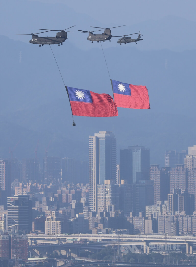 國旗機隊8日吊掛巨幅中華民國國旗進場,飛越台北市區上空。中央社記者趙世勳攝 114年10月8日