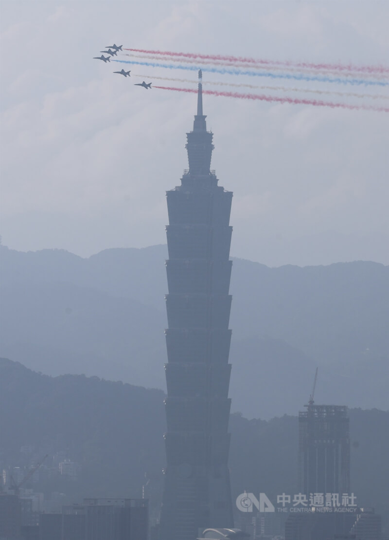 國軍8日上午進行空中全兵力預演,勇鷹高教機5機編隊施放彩煙飛過台北101大樓上空。中央社記者趙世勳攝 114年10月8日