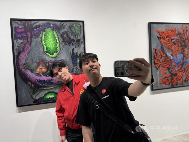 台灣「塗鴉俱樂部」在曼谷展出,吸引許多泰國民眾參觀。圖為泰國民眾與展出的塗鴉作品合照。中央社記者李宗憲曼谷攝 114年10月9日