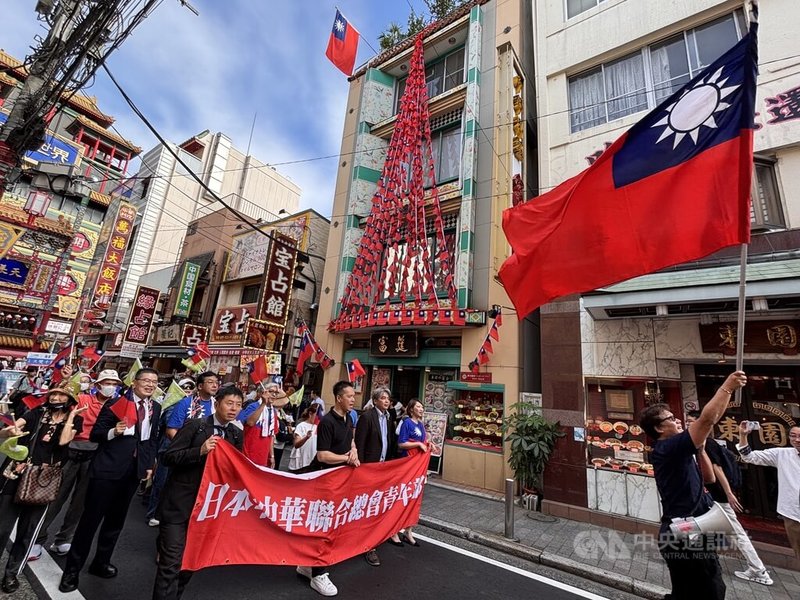 慶賀中華民國114年國慶,留日橫濱華僑總會10日在橫濱舉辦表演及遊行。遊行隊伍揮舞巨大國旗,與台灣人經營、因為掛滿中華民國國旗而知名的餐廳相互輝映。中央社記者戴雅真橫濱攝 114年10月10日