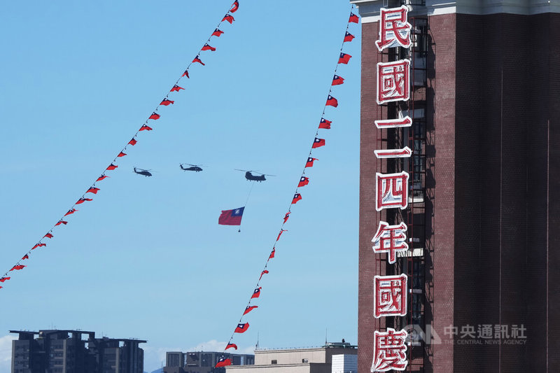 114年國慶大會10日在總統府前廣場舉行,進行至國歌領唱儀式時,空中2架UH-60M黑鷹直升機伴飛1架吊掛巨幅國旗的CH-47SD契努克運輸直升機,一同飛越凱達格蘭大道上空。中央社記者徐肇昌攝 114年10月10日