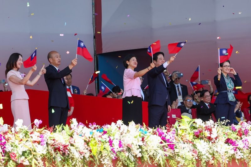 114年國慶大會10日在總統府前登場，總統賴清德（前左4）與夫人吳玫如（前左3）、副總統蕭美琴（前右）、立法院長韓國瑜（前左2）與夫人李佳芬（前左）向榮耀英雄車隊揮舞國旗致意。中央社記者王騰毅攝　114年10月10日