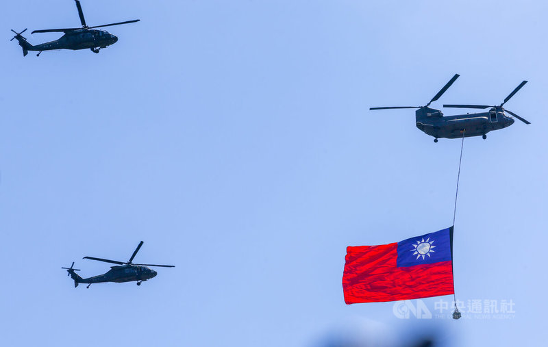 114年國慶大會10日在總統府前廣場舉行,國歌響起時,1架CH-47SD契努克運兵直升機吊掛巨幅國旗,伴隨2架UH-60M黑鷹直升機飛越總統府前方廣場上空。中央社記者王騰毅攝 114年10月10日