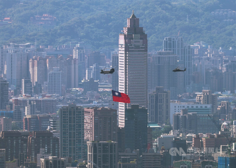 雙十國慶大會10日盛大舉行,國旗機隊吊掛巨幅國旗飛越台北市區上空,展現國軍訓練成果。中央社記者趙世勳攝 114年10月10日