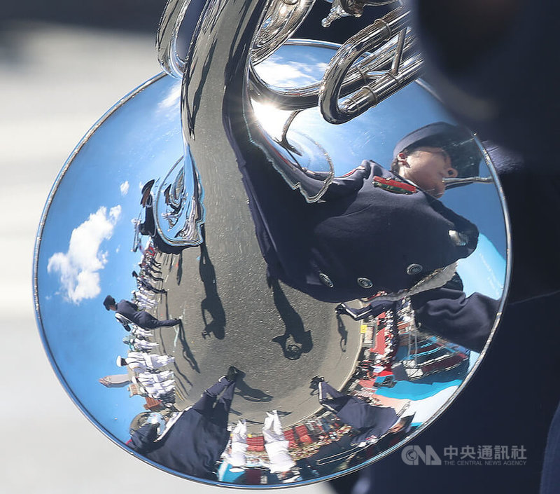 國慶大會10日在總統府前廣場登場，國防部聯合樂隊過程帶來多首軍歌、職棒應援曲等曲目。圖為樂隊吹奏法國號時，樂器上反射周邊樂隊演出情形。中央社記者張新偉攝　114年10月10日
