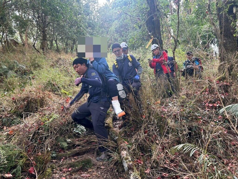 台南市一對夫妻11日至阿里山攀登路況較陡峭的兒玉山路線,不料妻子不慎摔倒導致左腳踝疑脫臼,嘉義消防人員獲報上山援救,以背架將人揹負接駁下山。(嘉義縣消防局提供)中央社記者黃國芳傳真 114年10月11日