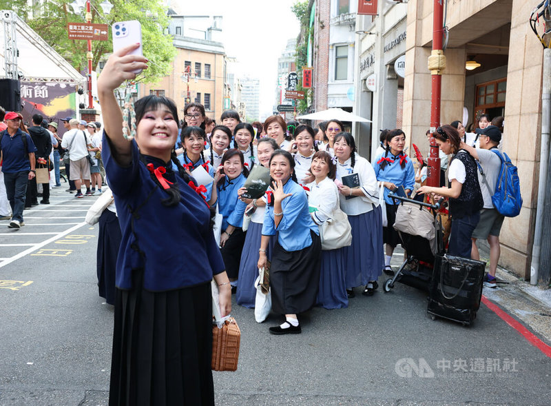 2025大稻埕國際藝術節已開跑，12日許多民眾換上復古服裝參與「1920變裝活動」，開心在大稻埕街區合影留念。中央社記者謝佳璋攝　114年10月12日