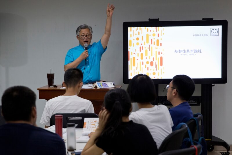 圖為2018年北京錫安教會牧師金明日（站立者）帶領信徒學習基督教信仰基礎。（美聯社）